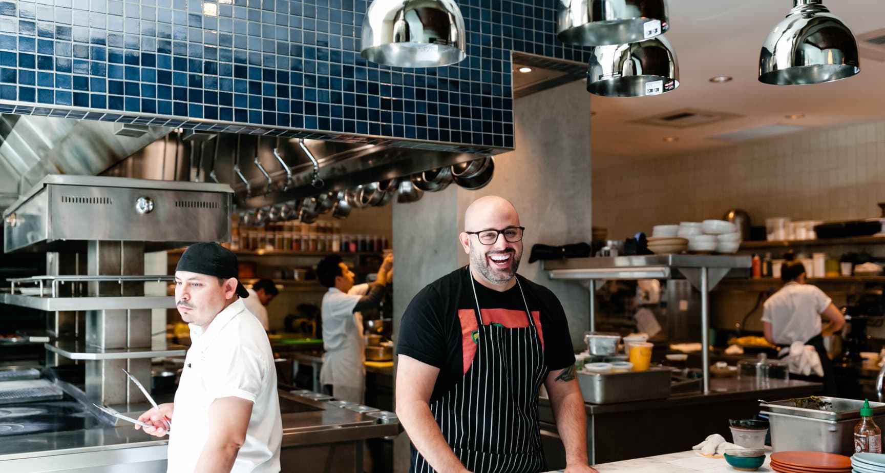 A chef working in a kitchen smiling