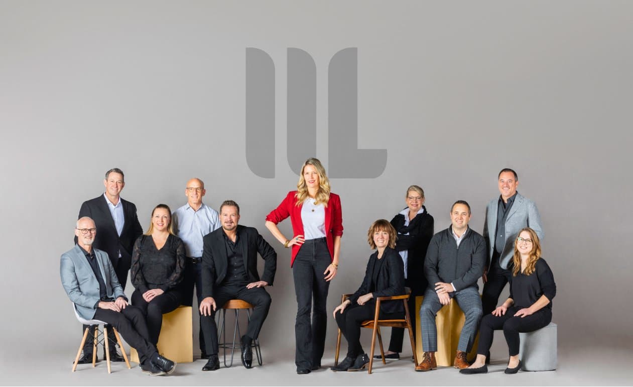 A group of people posing in front of a grey background